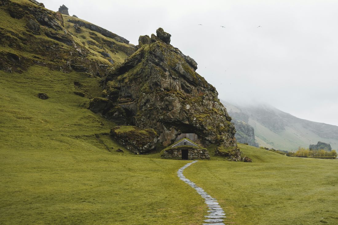 A winding stone path leading to a house built into a hillside